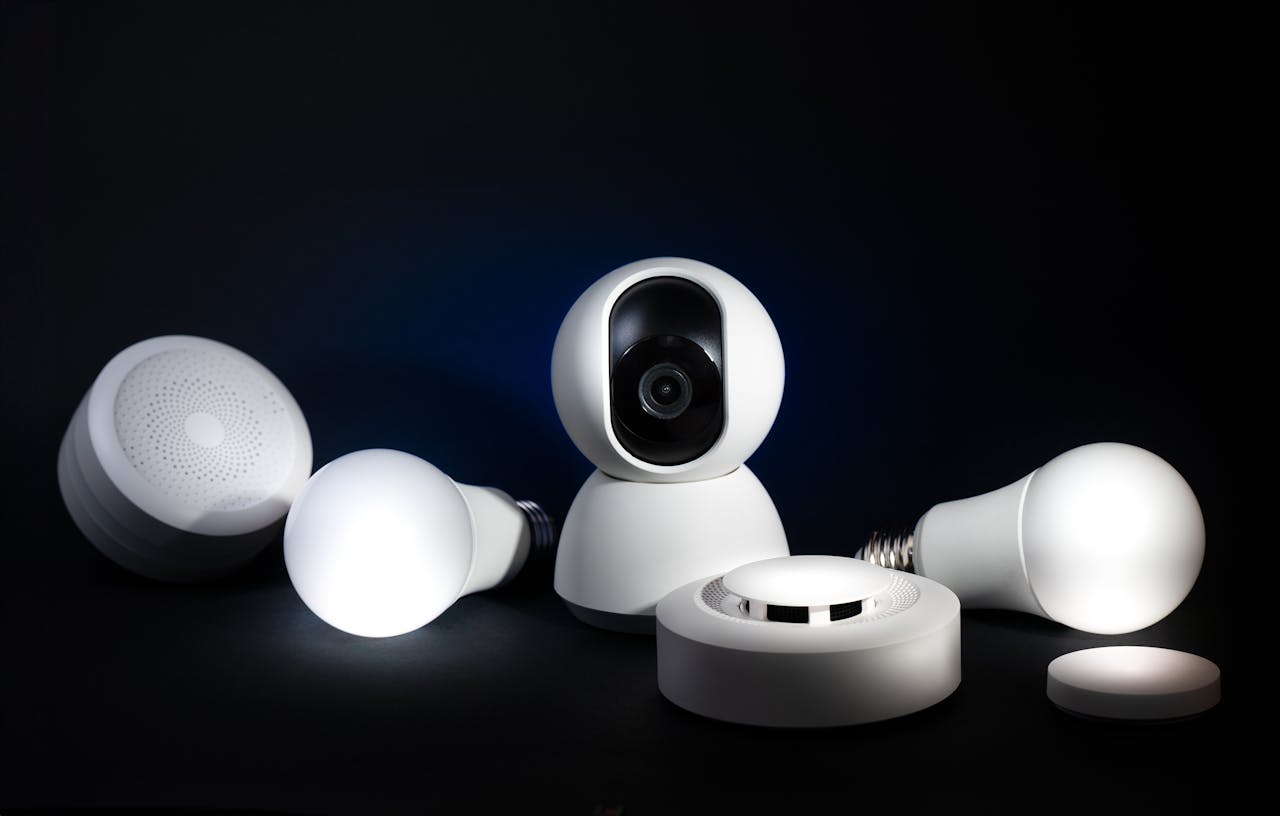 A collection of smart home devices, including bulbs and security cameras, on a dark background.